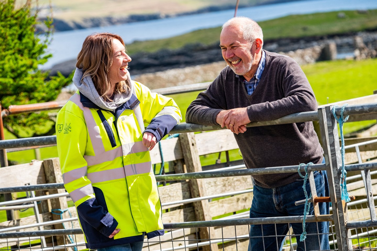 Sharon Powell, our Shetland Community Liaison Manager, speaks with a member of the local community by a fence.