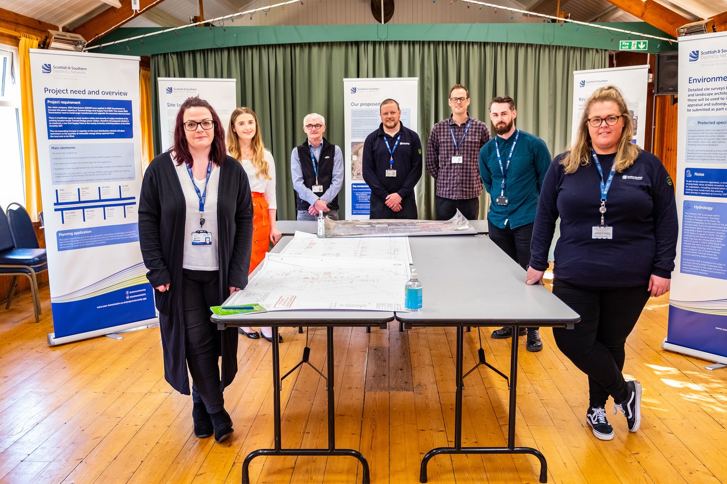 A team of SSEN Transmission staff members stand around a table at our community consultation events.