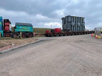 A large section of substation infrastructure on a large flatbed trailer attached to a heavy haulage vehicle.