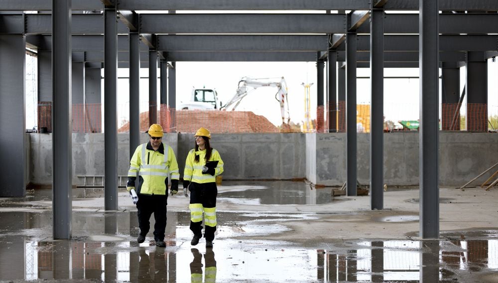 Two colleagues on a building site wearing protective clothing