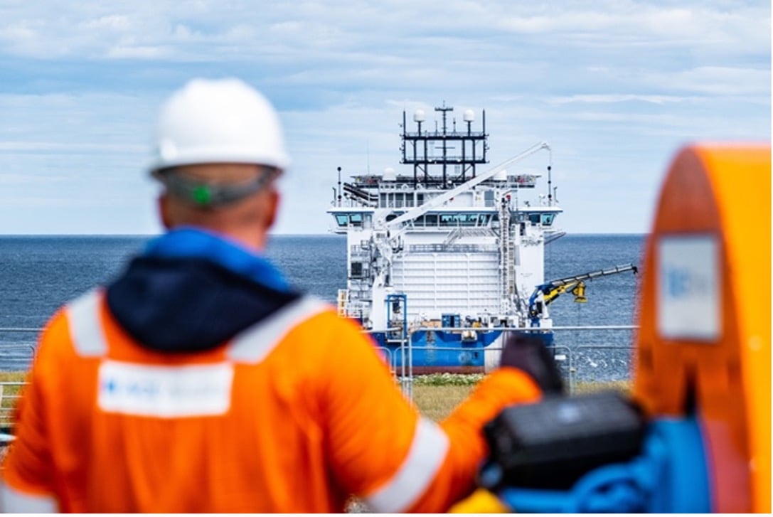 An operative looks towards the sea where he can see a cable-laying vessel being used in Shetland.