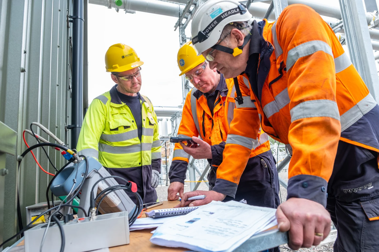 Colleagues in PPE looking at documents on site
