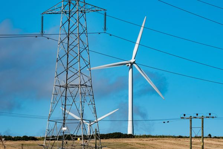 Transmission lines with wind turbines in the background