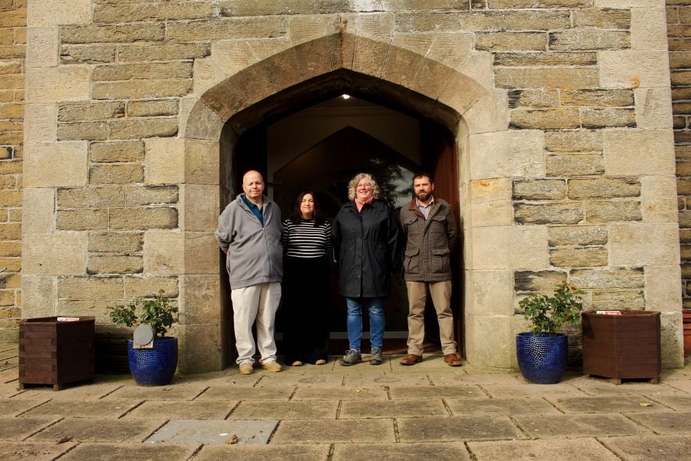 Four members of the Wick Development Trust standing at the door of St Fergus Church in Wick