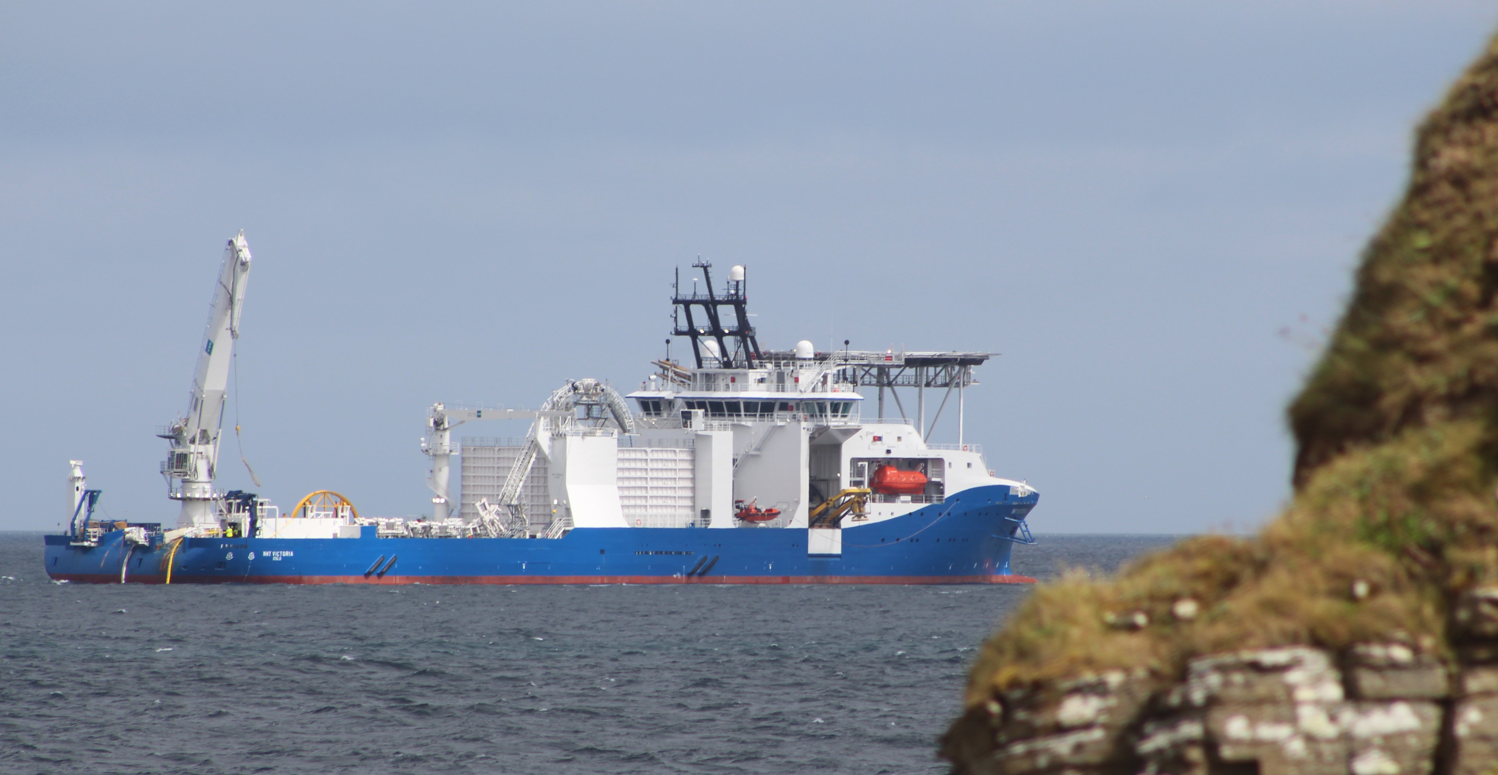 NKT Victoria large ship with a helipad on the foredeck at sea.
