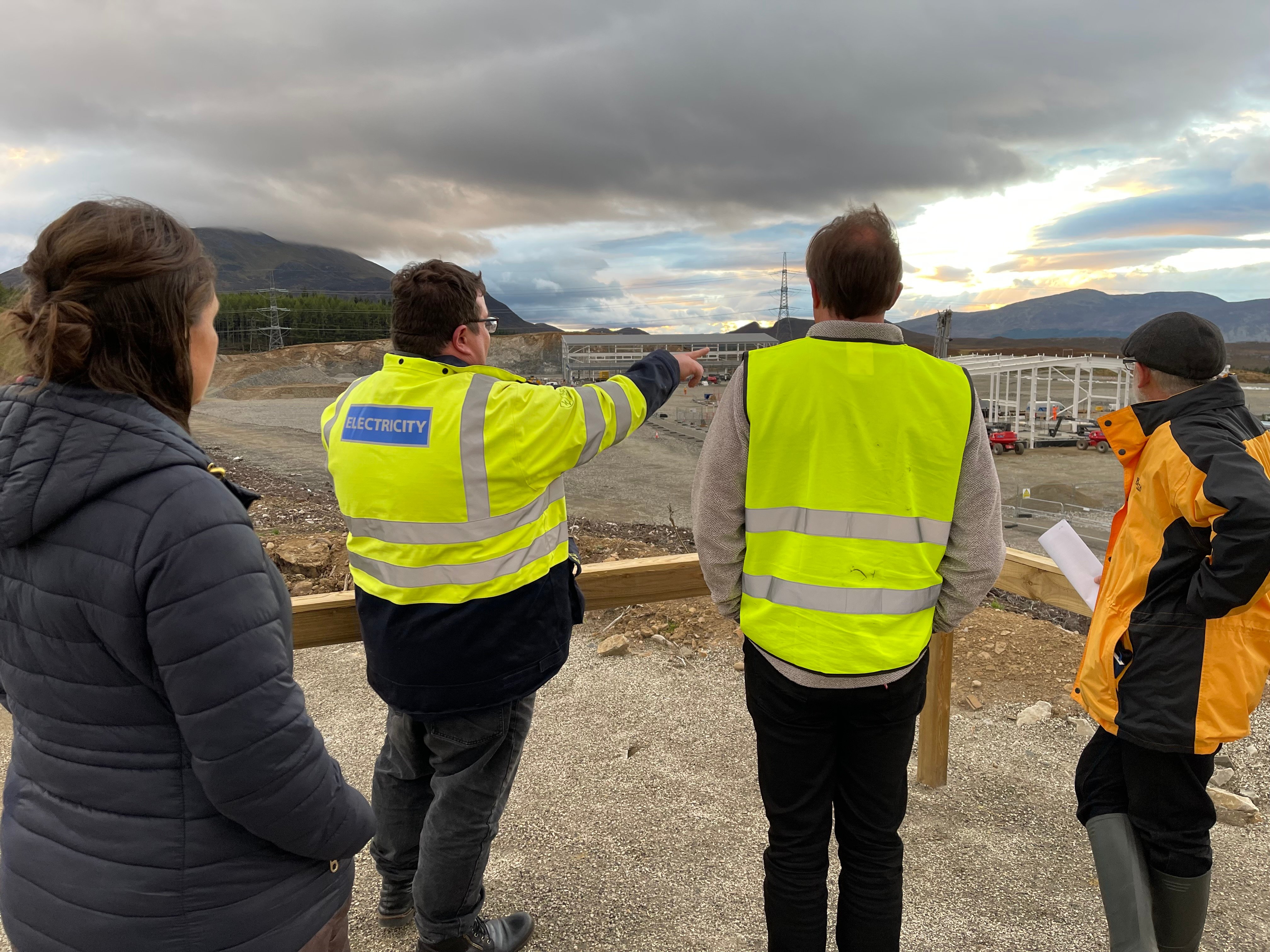 Members of the public and SSEN Transmission employees at the viewpoint of a substation under construction.