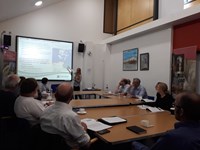 Members of the public with SSEN Transmission staff at tables in front of a projector slide.