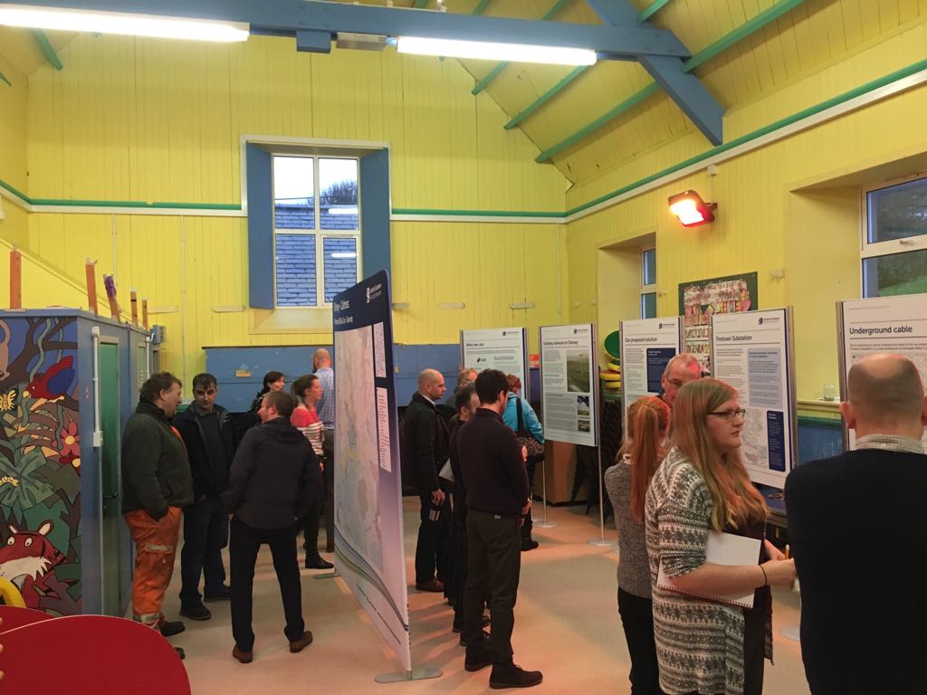 Consultation Members of the public with SSEN Transmission staff in front of project posters.