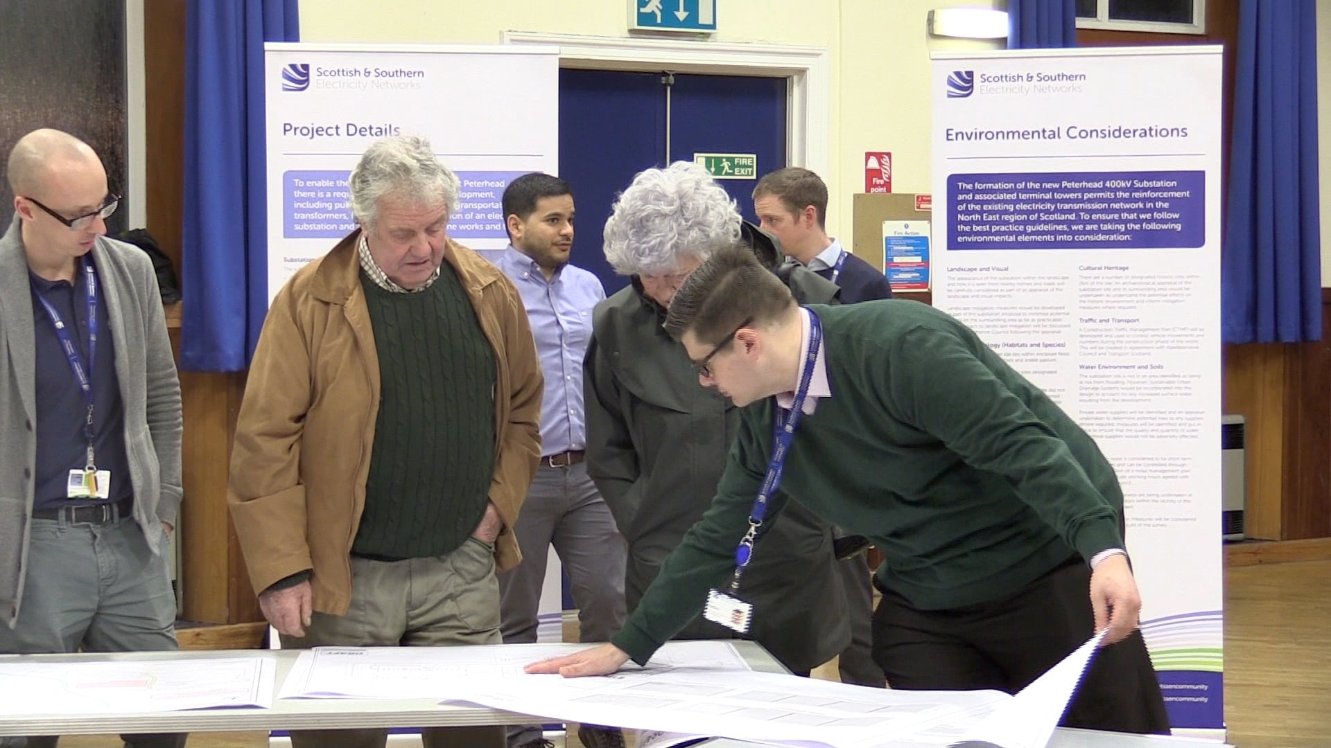 Consultation event SSEN transmission employees and members of the public examining maps.