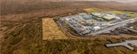 An aerial view of a substation under construction in a rural area.
