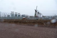 A rough stone surfaced area below a substation on a raised area.