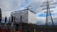 Wrapped scaffolding surrounded by substation infrastructure