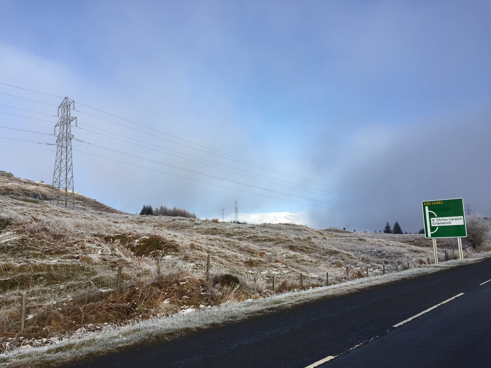 Glen Falloch A frosted bank next to a road, a sign reads "A82 (A85)", and "A Crion Laraich / Crianlarich".