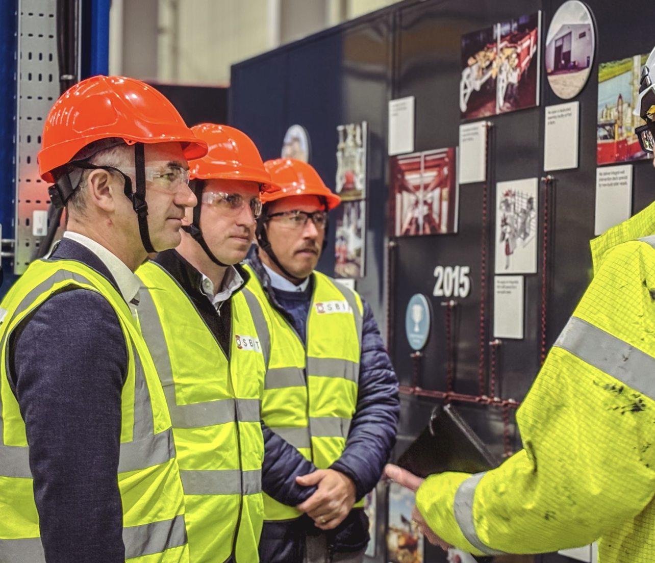 Image of SSEN Transmission collegues with NKT onsite looking at a workboard and speaking with a colleague 