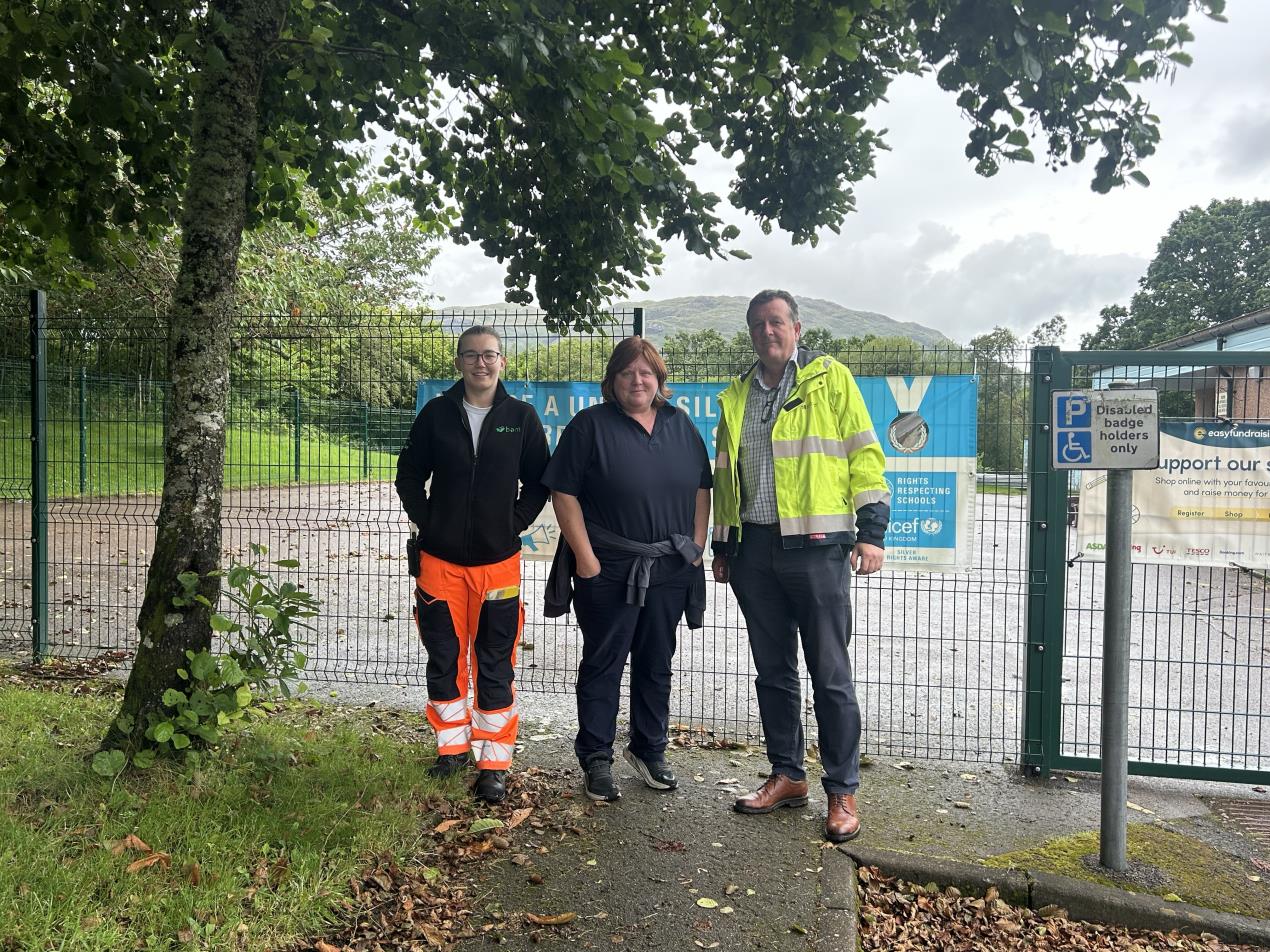 Three people standing in front of the new Taynuilt school fence. Left to right: Bethan Cameron, BAM Section Engineer, Berni McMillan, Headteacher, Taynuilt Primary School, David Fraser, SSEN Transmission Lead Project Manager