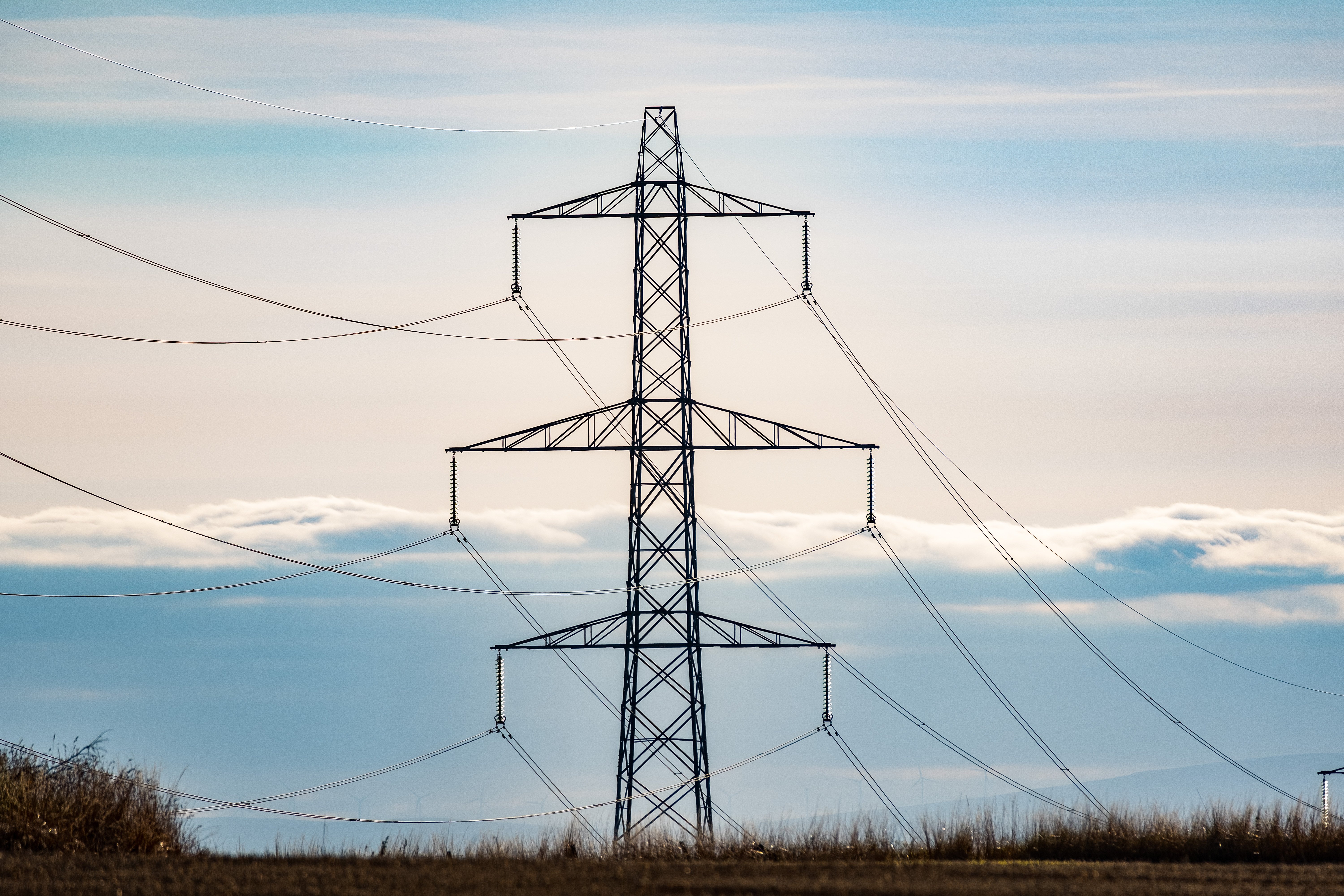 A metal transmission tower in front of a skyline.