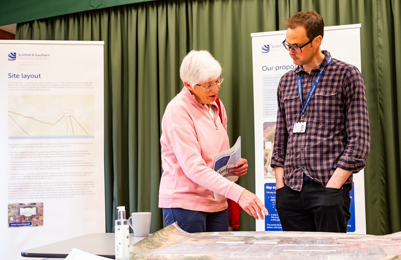 A member of the local community engages with an SSEN Transmission employee on plans for an upcoming project, demonstrating our community focus and collaborative approach.