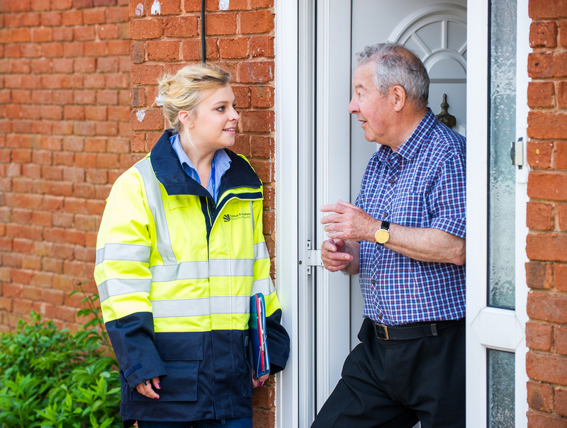 An SSEN Transmission employees speaking with a member of the public at their door.