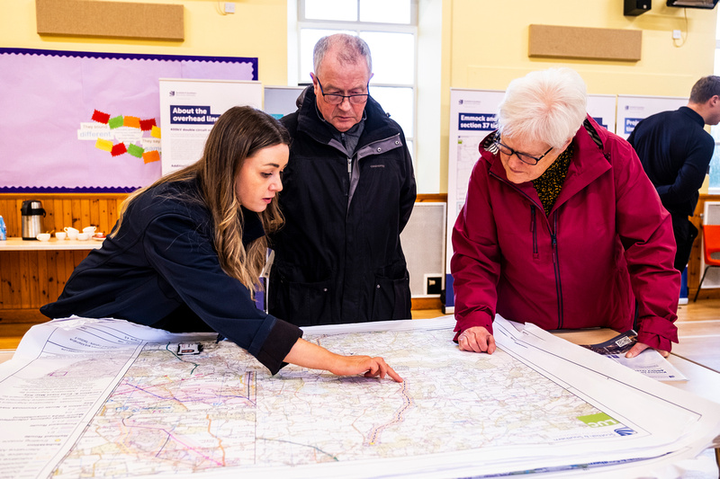 An SSEN Transmission employees speaking with a member of the public outside a residential house.