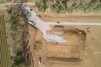 An overhead view of cleared dirt construction area next to an access road.