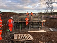 Workers approaching scaffolding on site.