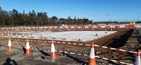 A large concrete slab within an excavated area of a construction site.