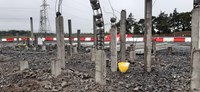 A concrete section with several lengths of rebar emerging from it.