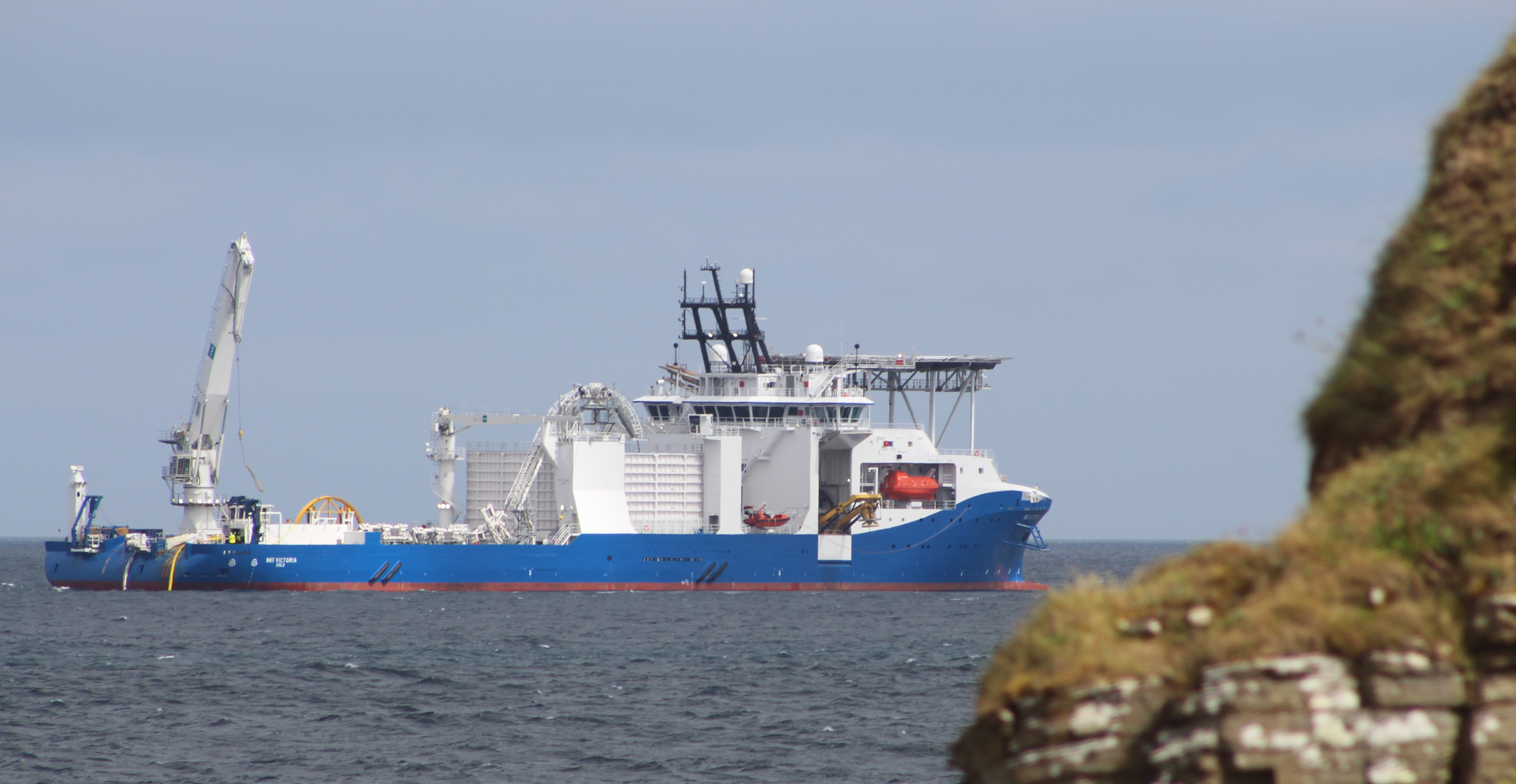  large ship with a helipad on the foredeck at sea.