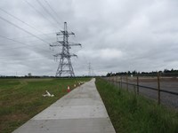 Metal panels forming a path along a grassy field.