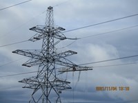 A metal transmission tower, a platform hangs below one of the arms. Orange text on the image reads "2021/11/04 13:16".