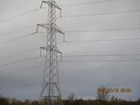 A metal transmission tower, a ladder hangs below one of the arms. Orange text on the image reads "2021/11/12 09:34".