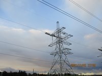 A horizontal platform suspended from the arm of a metal transmission tower. Contractors in PPE stand atop the platform.  A date in the corner reads "2021/11/01 17:09".