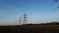 A series of metal transmission towers forming an overhead line.