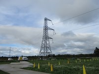 A metal transmission tower, 3 structural arms extending from one side.