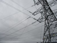 A transmission overhead cable partially attached to a metal transmission tower.