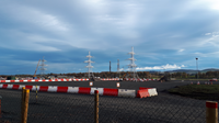 Metal transmission towers in front of a sunset.