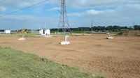 Four concrete blocks embedded in the ground. Metal supports emerge from the concrete.