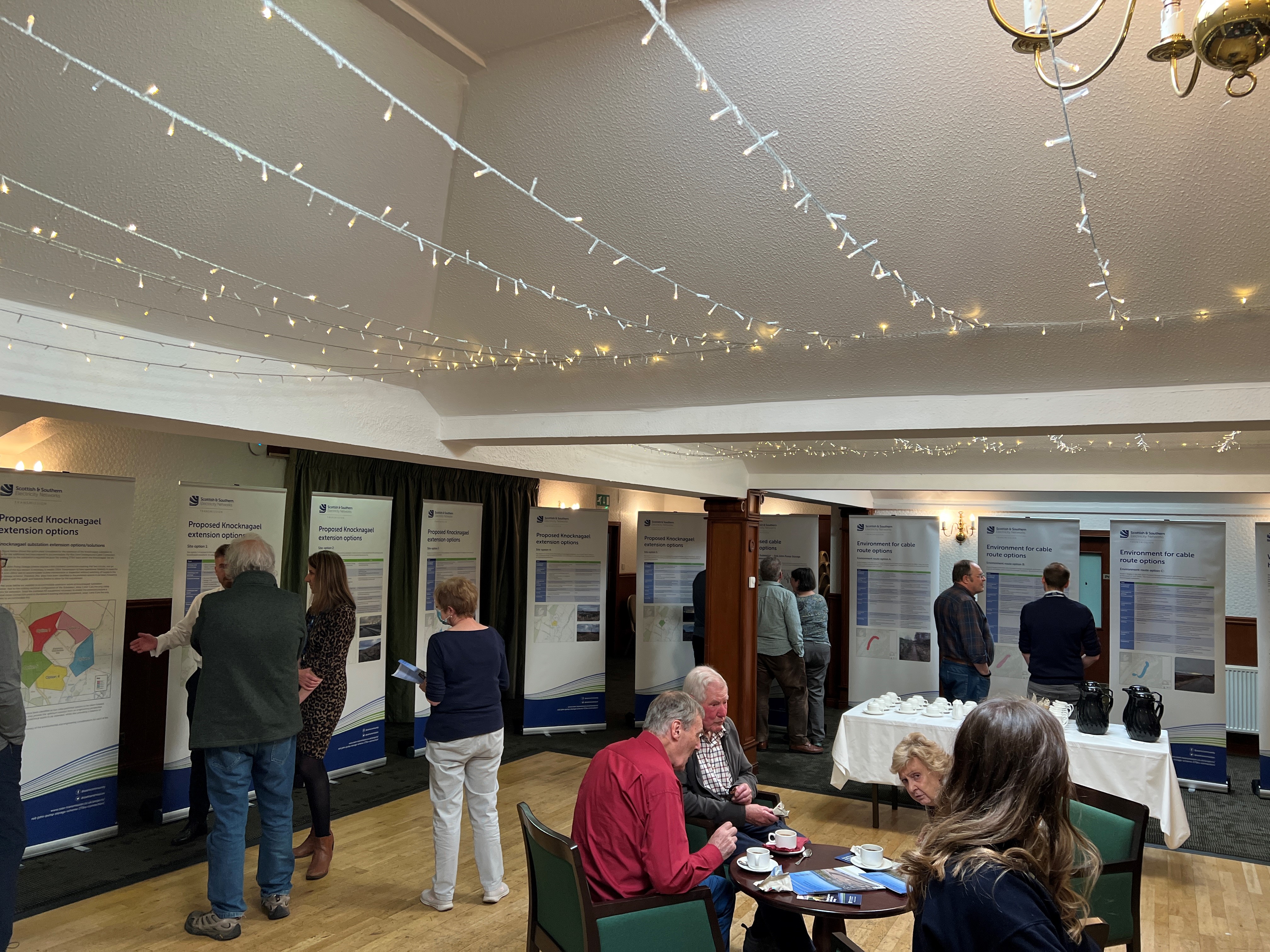 Members of the public examining project posters in a hall.