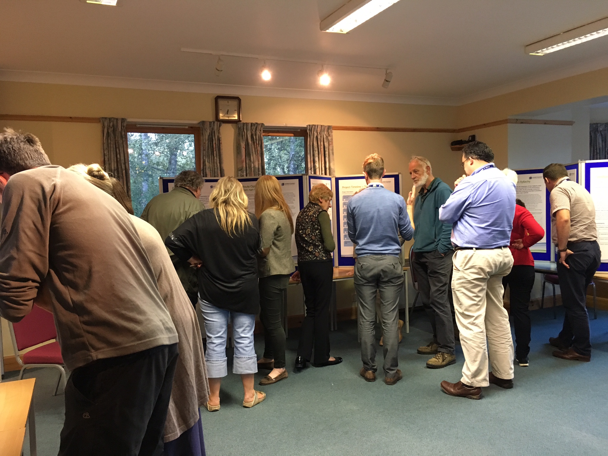 Members of the public and SSEN Transmission employees examining posters.