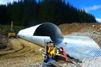 A tubular corrugated metal structure on a construction site.