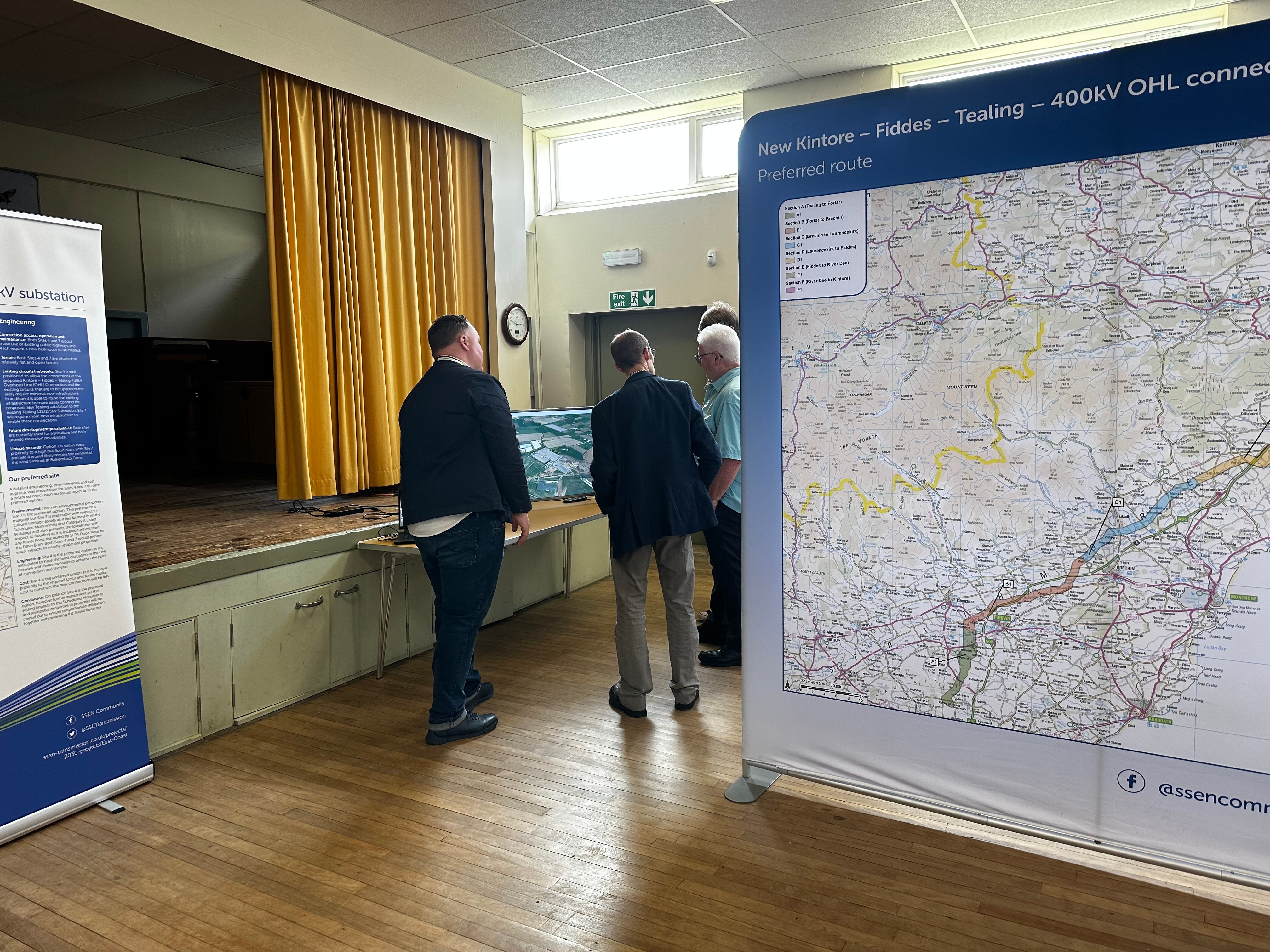 Members of the public and SSEN Transmission employees examining project posters in a hall.