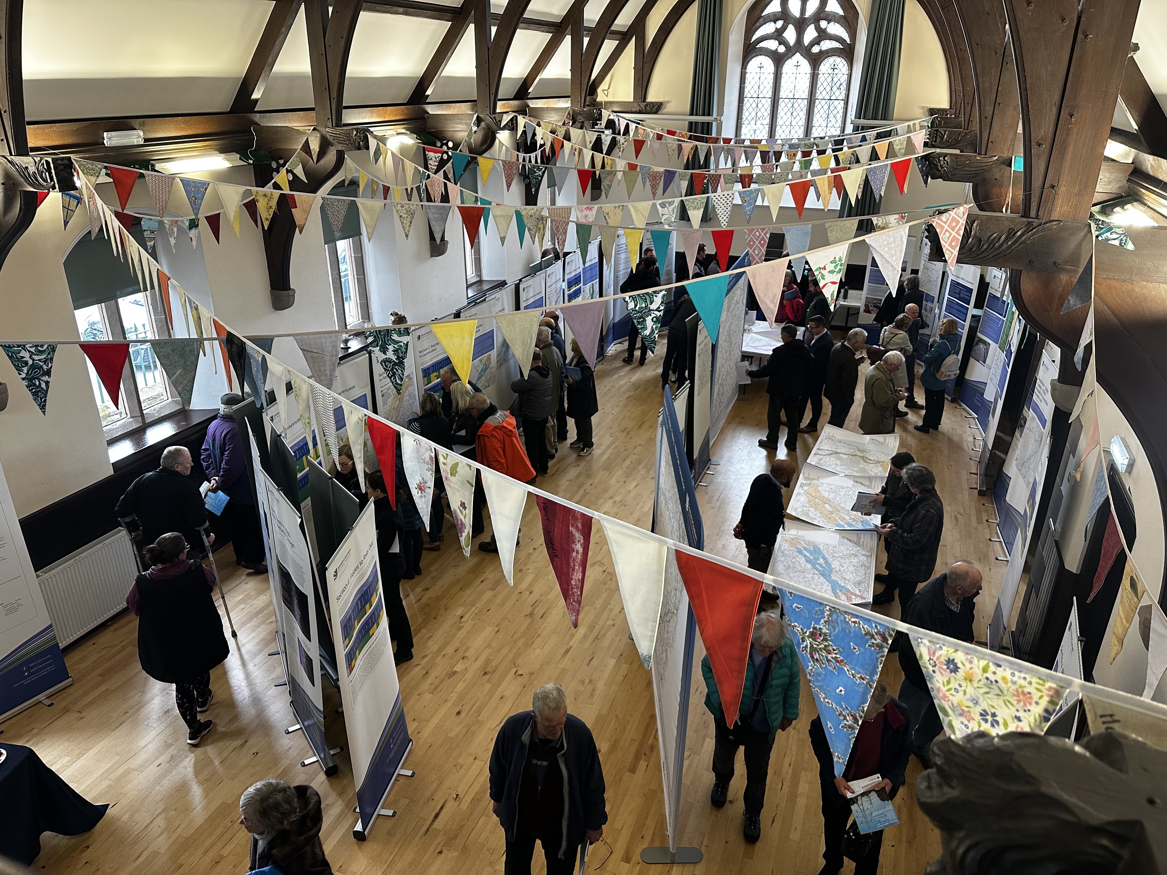 Members of the public and SSEN Transmission employees examining project posters in a hall.