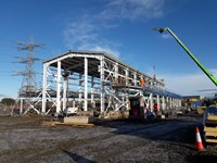 The metal frame of a building within a substation under construction.