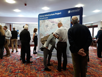 Members of the public with SSEN Transmission staff in front of a large map.