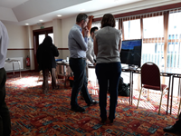 Members of the public with SSEN Transmission staff in front of a computer screen showing a visualisation of a junction.