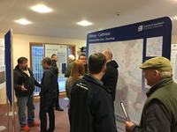 Members of the public with SSEN Transmission staff in front of a large map.