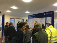 Members of the public with SSEN Transmission staff in front of a large map.