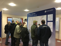 Members of the public with SSEN Transmission staff in front of a large map.