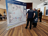 Members of the public with SSEN Transmission staff in front of a large map.