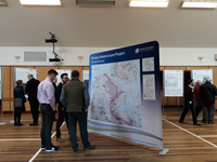 Members of the public with SSEN Transmission staff in front of a large map.